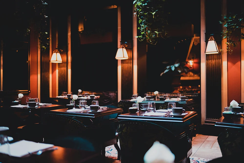 Tavolo di fine dining con accento sulla mise en place e pareti in luce morbida - fine dining illuminare il tavolo senza spegnere la sala illuminazione ristorante bar lucecontrocorrente