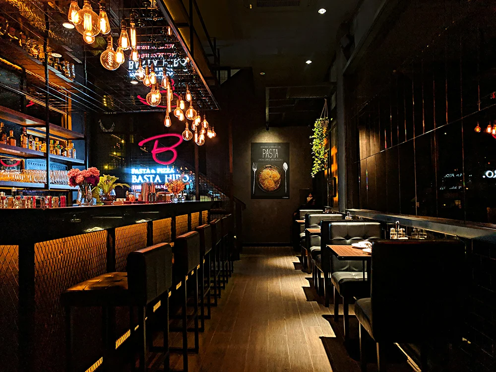 Bancone di bar con luce sul piano di lavoro, retrobanco e sgabelli - illuminazione bar il banco come centro del locale illuminazione ristorante bar lucecontrocorrente